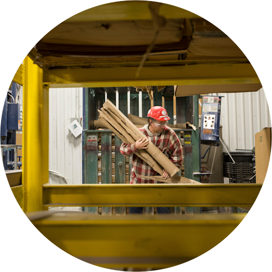 Clayton team member carries scrap cardboard that will be recycled