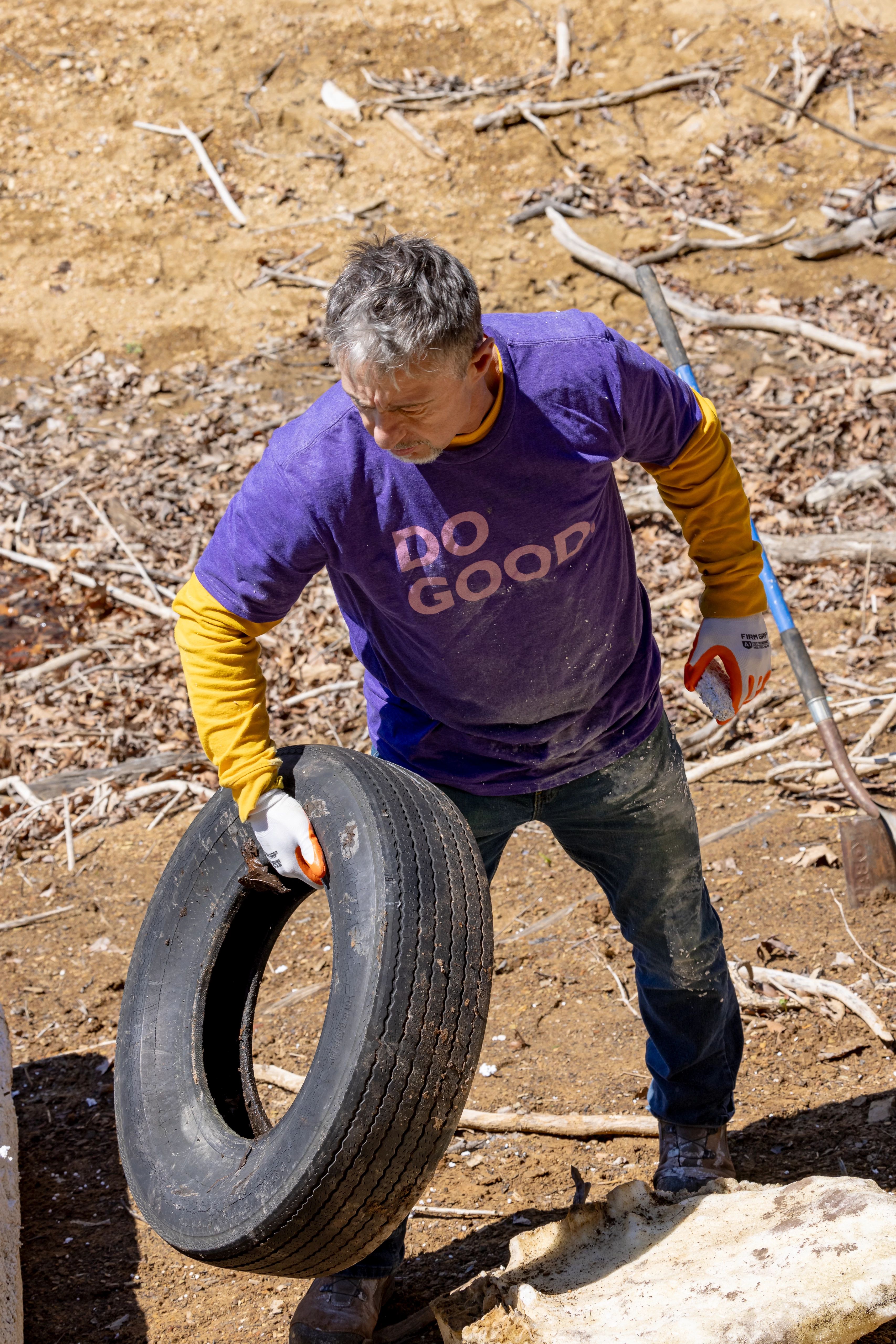 Team Member with tire in river cleanup