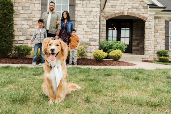 Family with dog posing in front of Clayton Home Building Group home