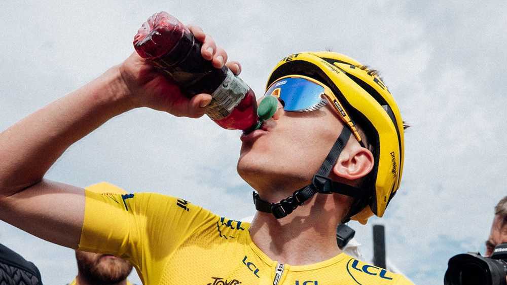 Tadej Pogacar enjoying cherry-flavored recovery drink for post-workout gains.