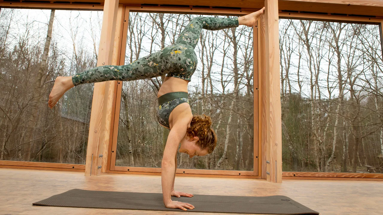 Lene Gissel står på händer på en yoga-matta