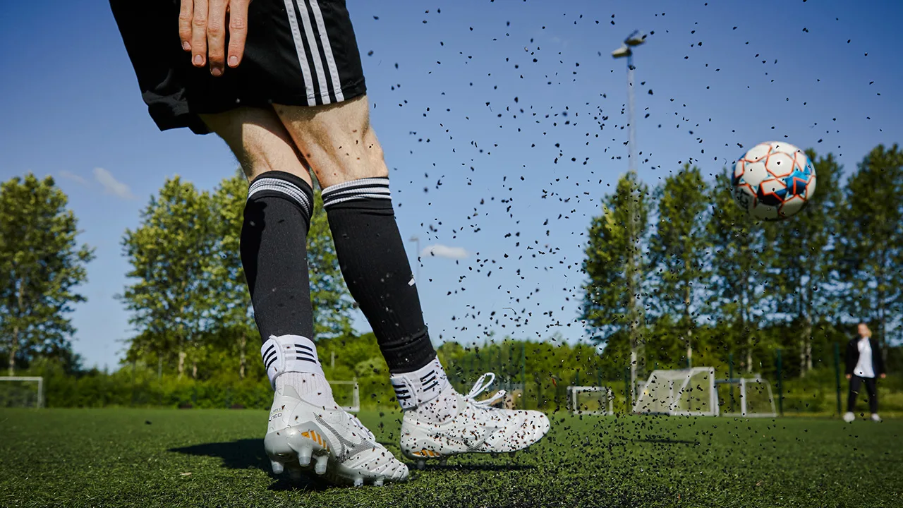Fußballschuhe, die einen Ball treten