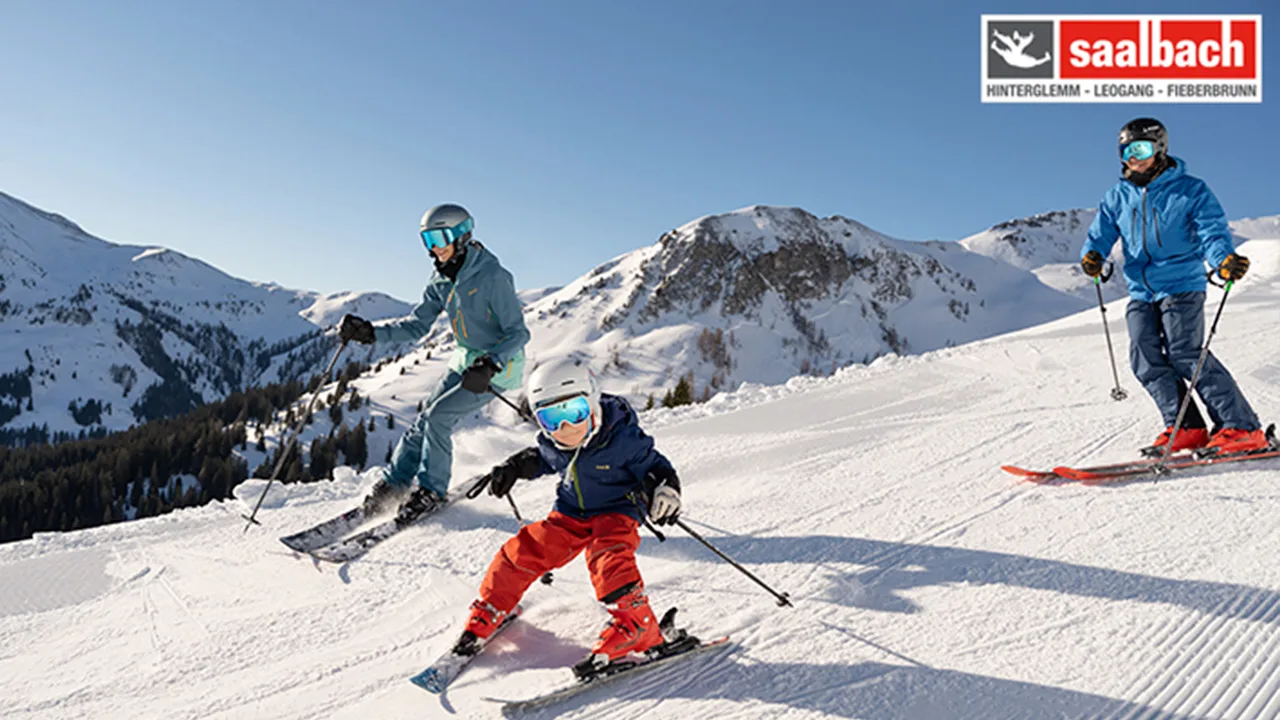 Familie på ski ned av bakke