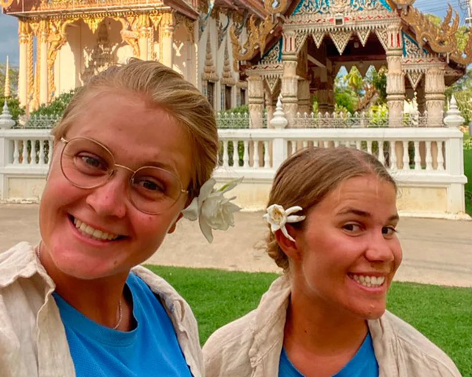 Sykkeljentene – selfie foran et tempel med blomst i håret