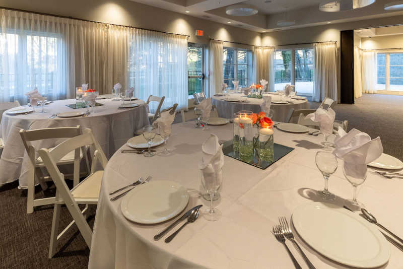 Round banquet tables with colorful centerpieces are arranged in The Residences at Biltmore's event space.