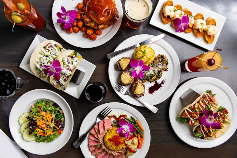 A spread of lunch and dinner items from Azalea Kitchen, including fresh salad, beef with coconut curry rice, ahi tuna tacos, filet medallions, and a burger.