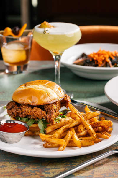 A hot chicken sandwich with fries.