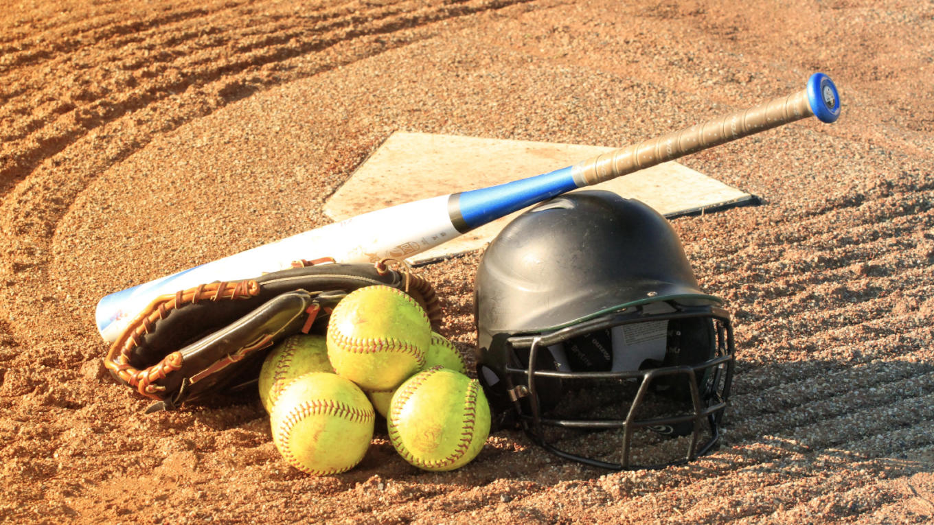 Softball equipment stacked next to home plate.