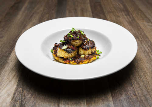 Traditions on the Lake's blackened scallops are served on a Cajun corn fritter and topped with a sweet bacon-pepper jam.