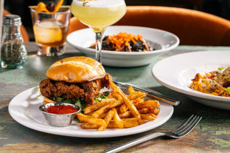 A hot chicken sandwich with a side of Voodoo fries.