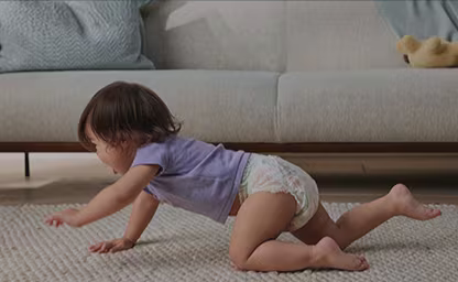 Crawling baby wearing a Pampers diaper made with natural ingredients