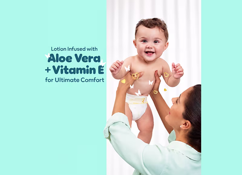 Happy baby held by mother with butterflies and hearts — Pampers Ultimate Comfort lotion infused with Aloe Vera and Vitamin E Happy baby held by mother with butterflies and hearts — Pampers Ultimate Comfort lotion infused with Aloe Vera and Vitamin E