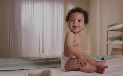 Happy baby sleeping soundly in Pampers best diaper for better sleep