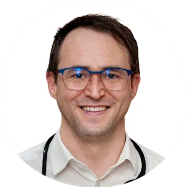 Male Intercare doctor smiling, wearing glasses and stethoscope — available on Unu Health.