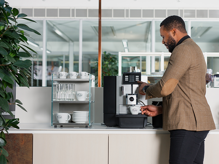 Employee taking coffee from a Jura coffee machine