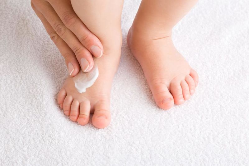 Lotion pour bébés sur le pied d'un tout-petit