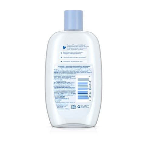 A white plastic bottle with a blue cap containing baby oil has text in English and Arabic on the back. The text instructs proper use and ingredient details.