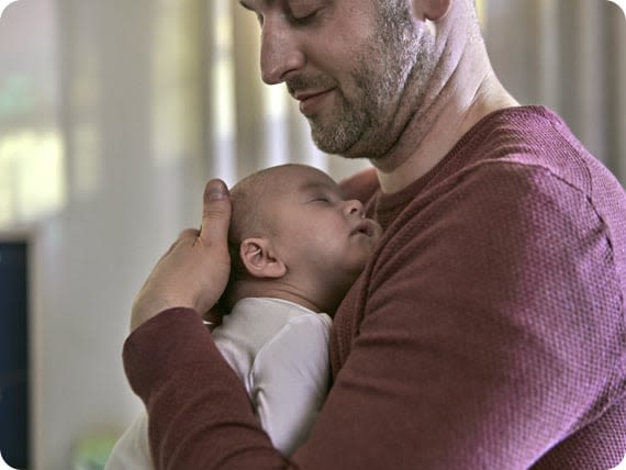 Dad holding his newborn baby against his chest