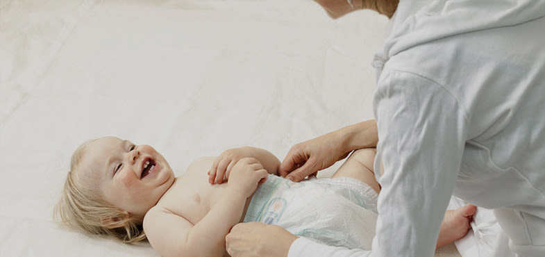 Bebê sorrindo em um cesto de roupa