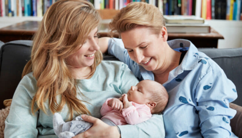 two mothers holding baby