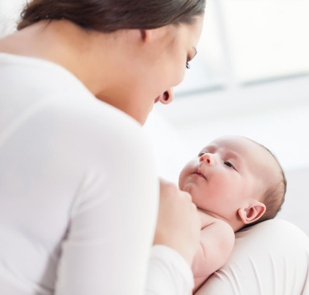 Mulher, criança e bebê sentados no sofá