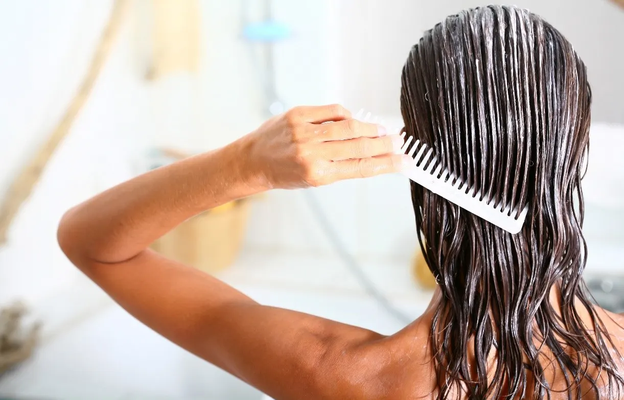 Woman applying Hair Conditioner to keep her hair hydrated