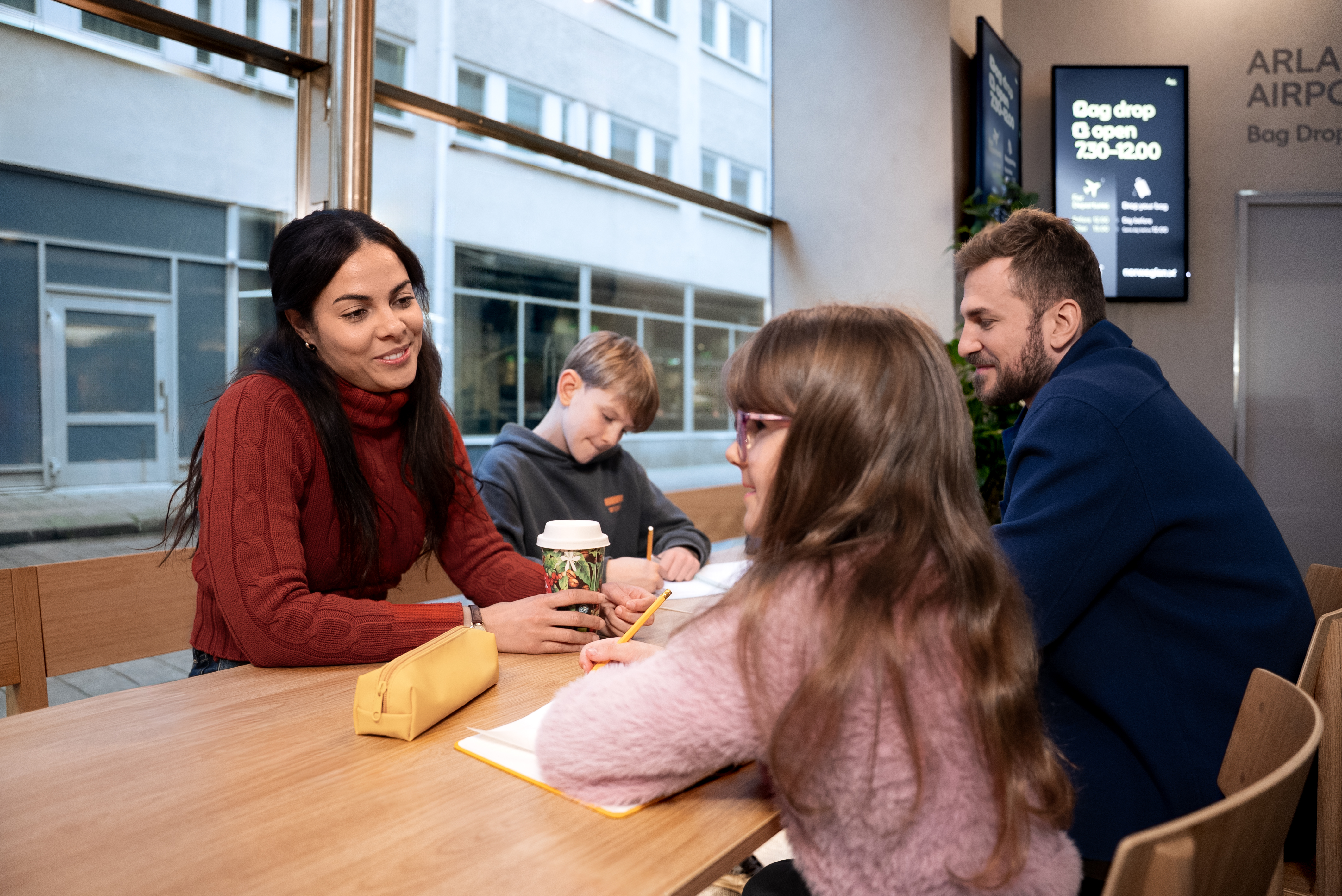 En familj som kopplar av tillsammans i Arlanda express ljusa lounge på Stockholm Central