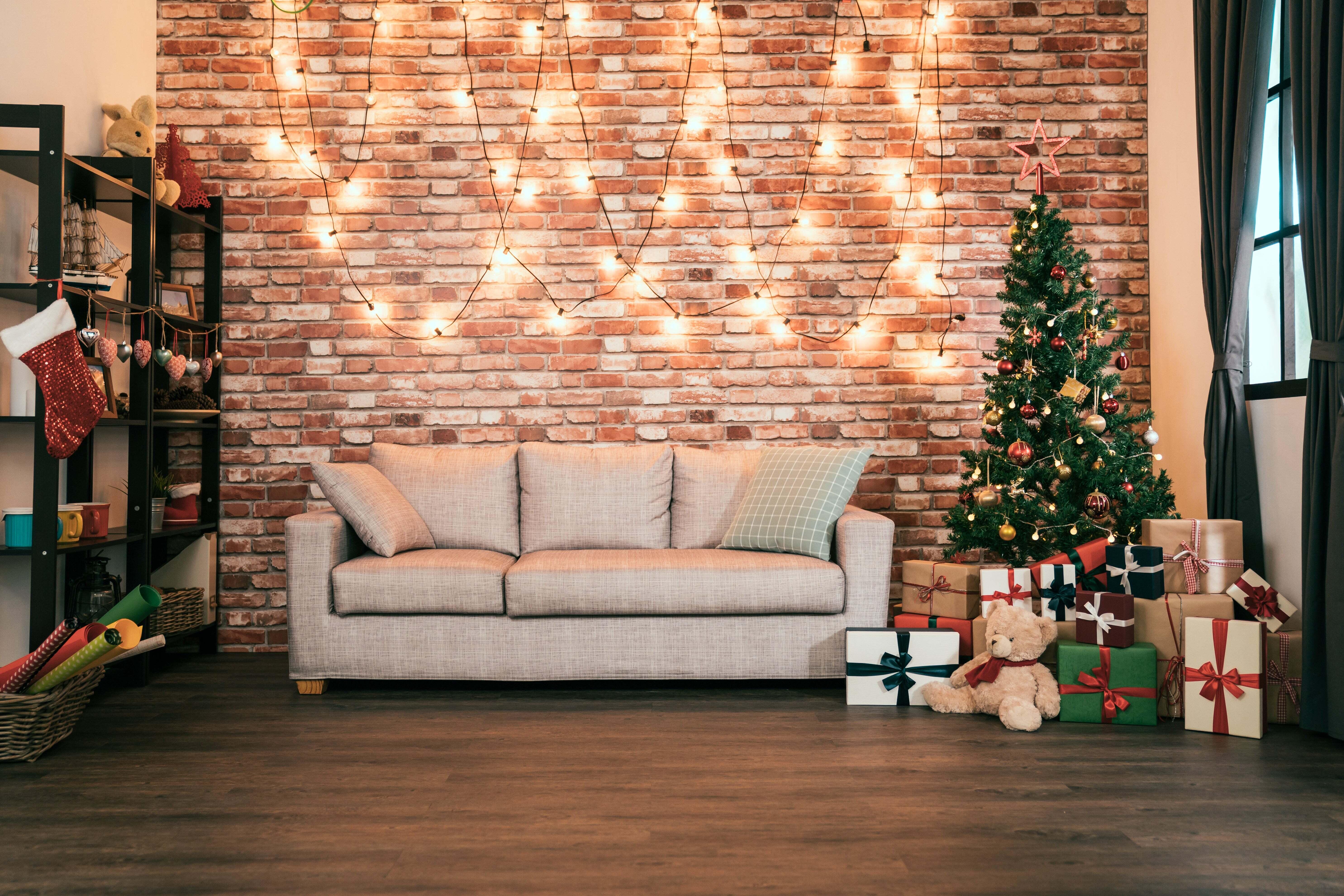 A living room decorated for Christmas with a tree, lights, and presents