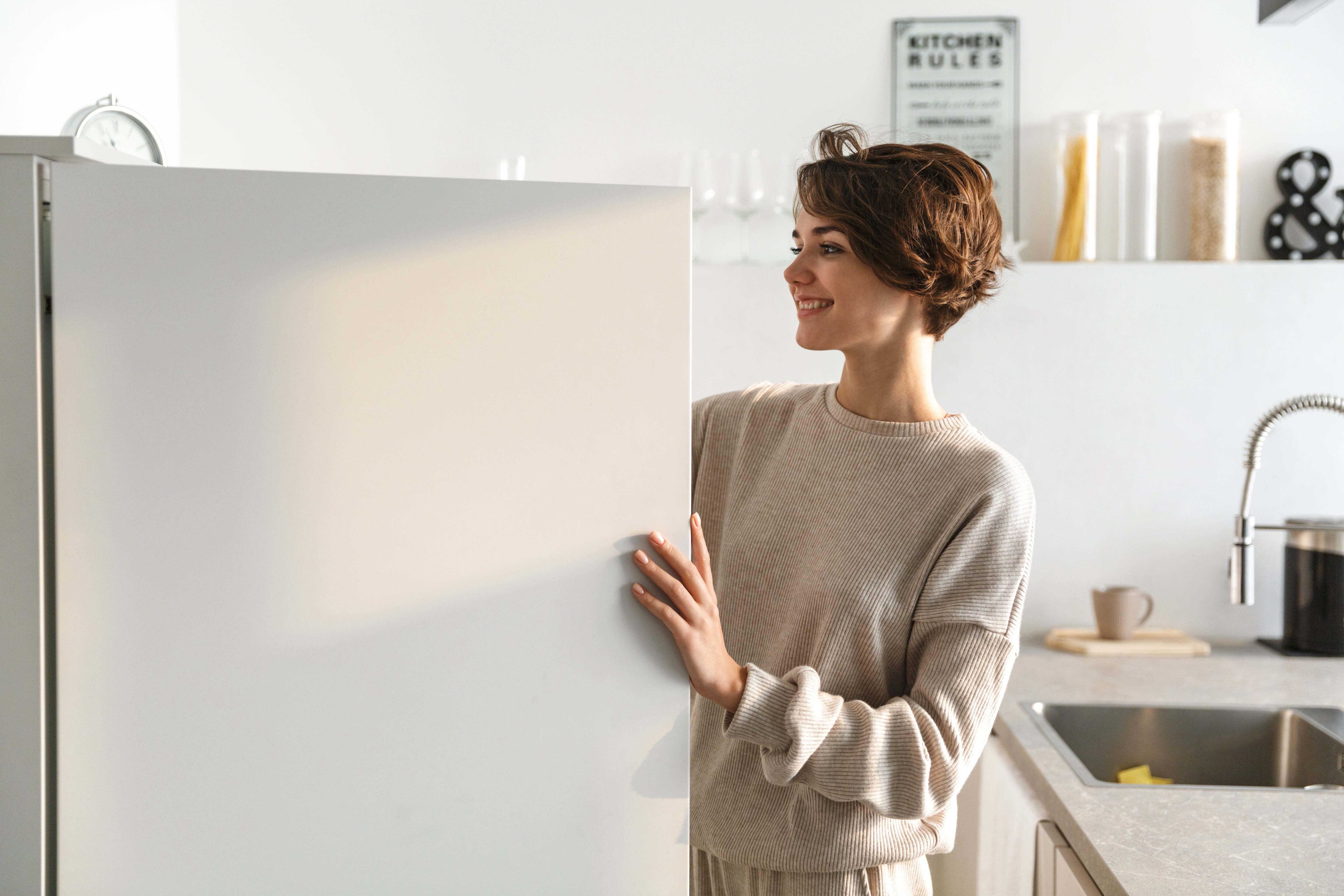 A woman reaching into her freezer