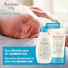 Front shot of Aveeno® Baby Healthy Start Newborn Wash and Balm products and a baby sleeping in the background