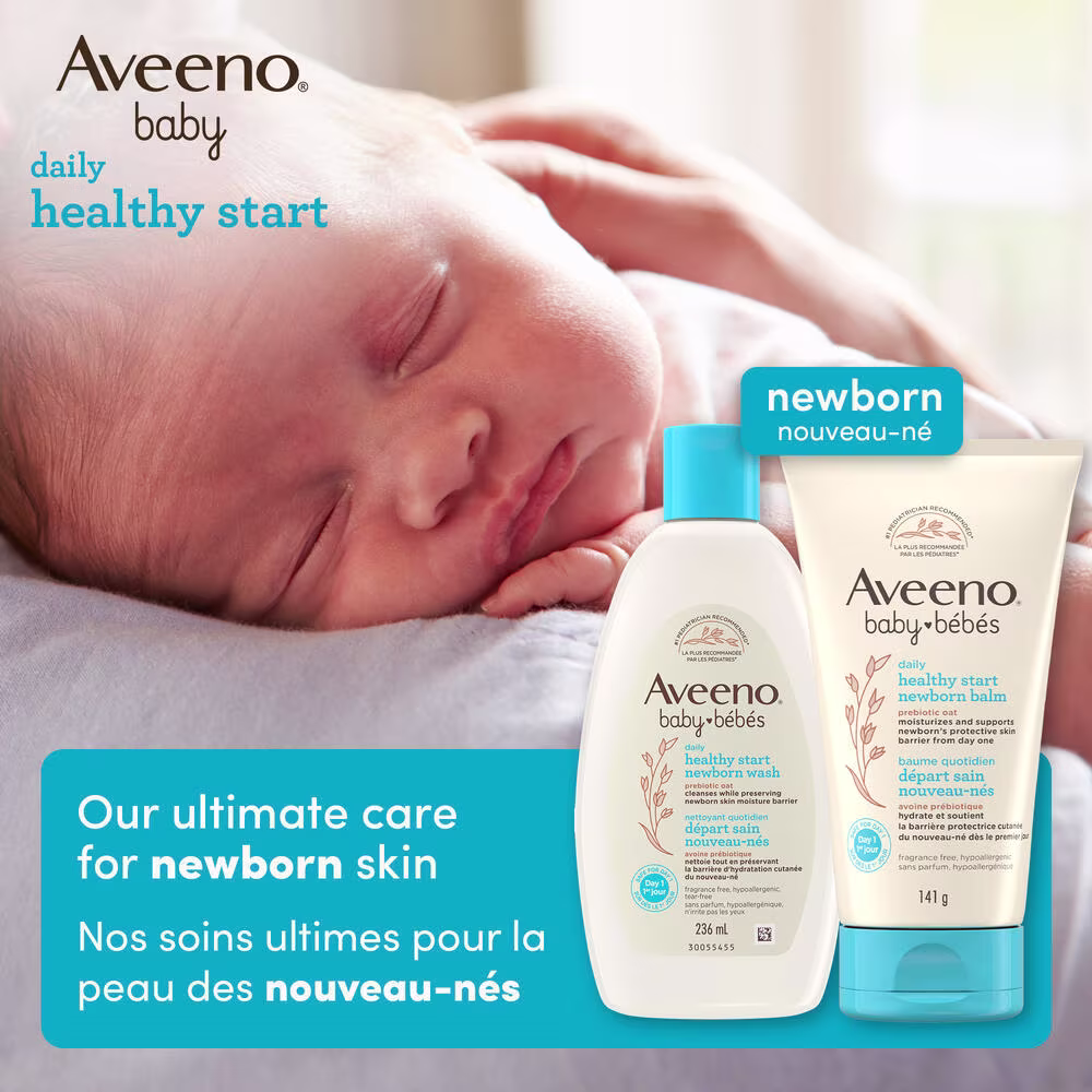 Front shot of Aveeno® Baby Healthy Start Newborn Wash and Balm products and a baby sleeping in the background