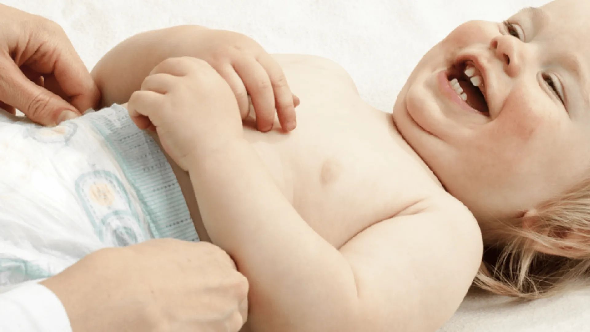 Image highlighting a baby during diaper change, demonstrating a moment of joy