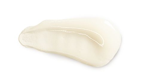 Shiny off white lotion on a white surface showcasing a light creamy texture
