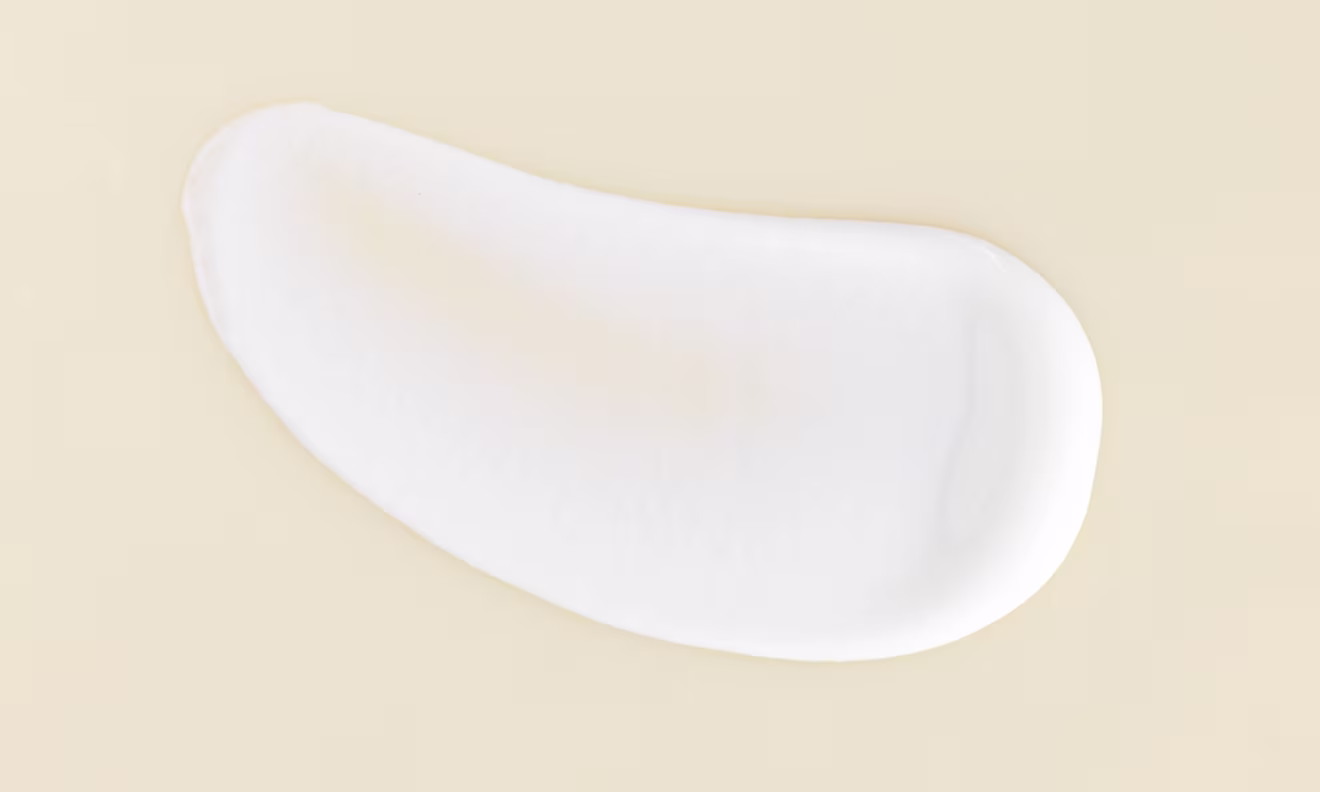 A delicate white cream positioned on a white surface showcasing its soft texture and uniform color