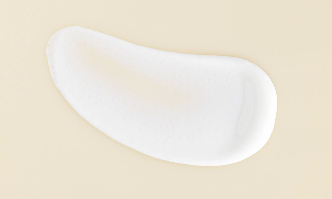 A delicate white cream positioned on a white surface showcasing its soft texture and uniform color