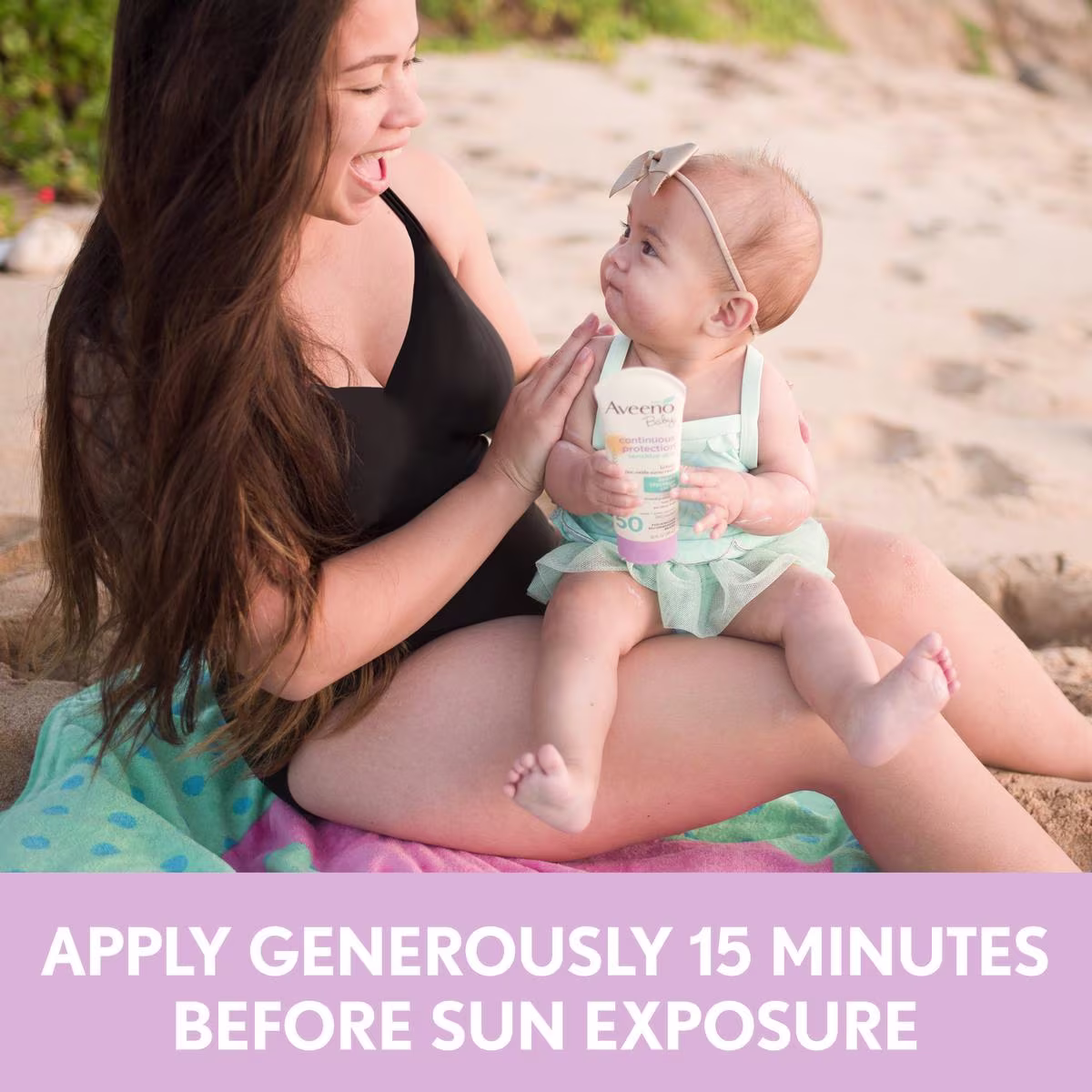 Woman applying Aveeno® sunscreen on her baby and text apply sunscreen 15 minutes before sun exposure
