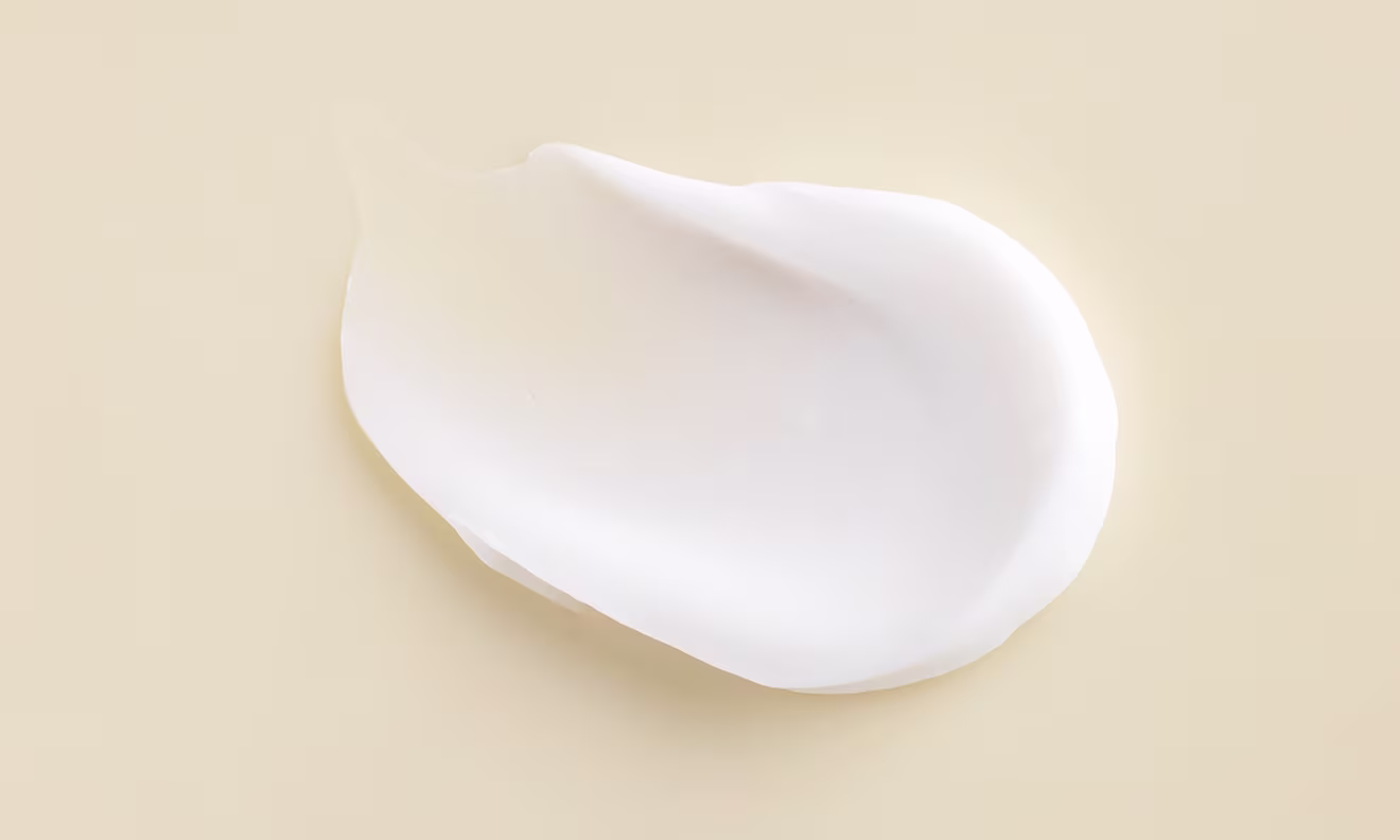 A delicate white cream positioned on a white surface showcasing its soft texture and uniform color
