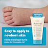 Photo de face du baume Départ sain pour nouveau-nés Aveeno® Bébés, 141 g, tube compressible, avec le pied d’un bébé en arrière-plan