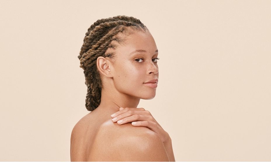 Woman gently resting her hand on her shoulder, promoting skin relief and comfort.