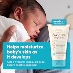 Front shot of Aveeno® Baby Healthy Start Newborn Balm, 141g, squeeze tube, and a baby on parent's shoulder sleeping in the background
