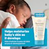 Front shot of Aveeno® Baby Healthy Start Newborn Balm, 141g, squeeze tube, and a baby on parent's shoulder sleeping in the background