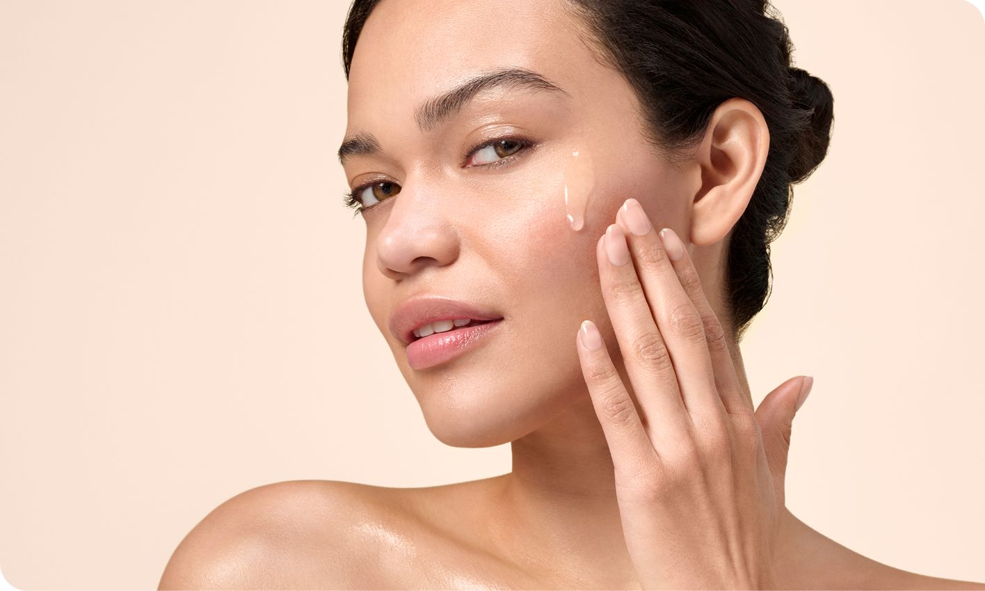 A woman with a radiant skin applying serum on her face