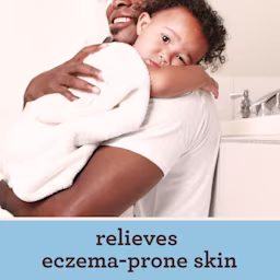 Man gently holds a baby in a bathroom showcasing a tender moment of care and connection between them