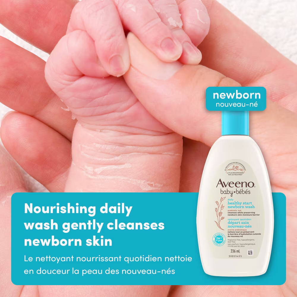 A4 Healthy Start Newborn Wash English French 2000x2000 Gently Cleanse JPG Front shot of Aveeno® Baby Healthy Start Newborn Wash squeeze bottle, 236ml, and baby's hand holding mother's hand in the background