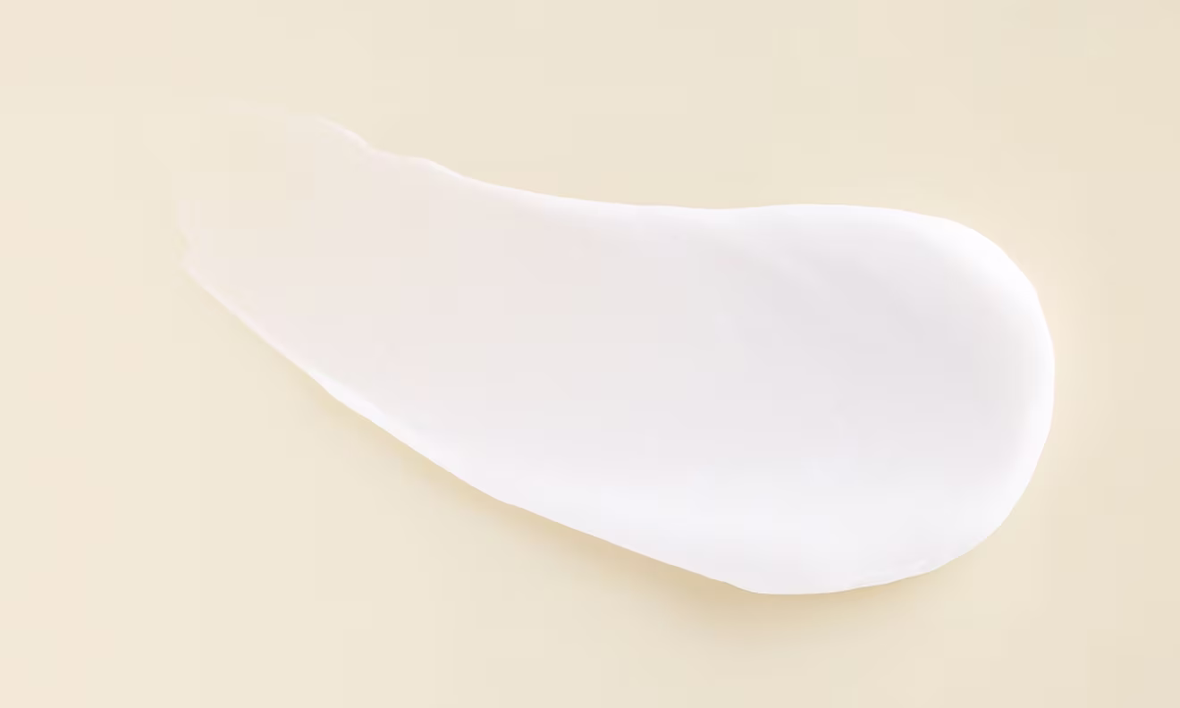 A delicate white cream positioned on a white surface showcasing its soft texture and uniform color