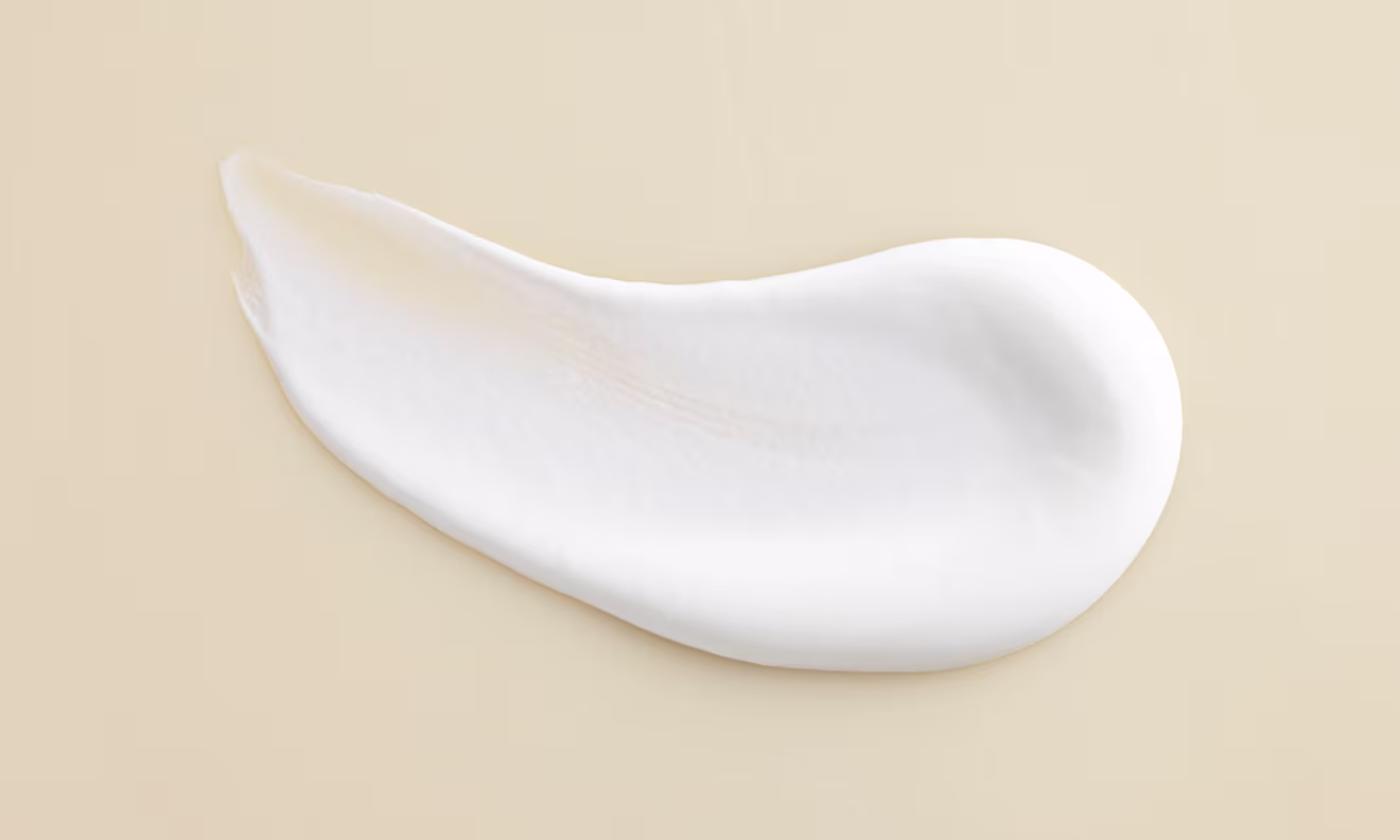 A delicate white cream positioned on a white surface showcasing its soft texture and uniform color