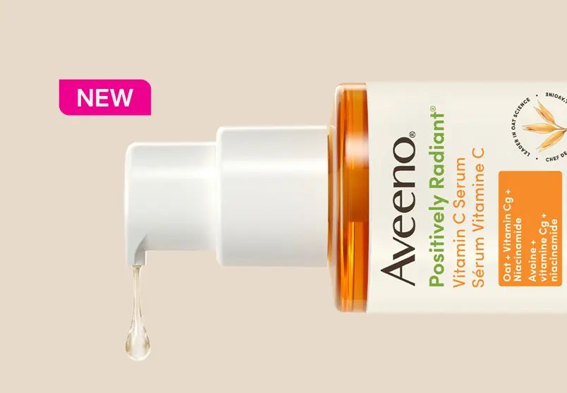 Woman smiling next to a jar of the Aveeno® Daily Moisturizing Cream.
