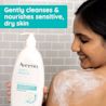 Woman bathing with Aveeno® Calm + Restore Body Wash bottle cleanses & nourishes sensitive dry skin