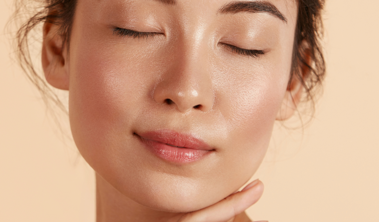 A woman with closed eyes gently rests her hands on her face, conveying a moment of tranquility