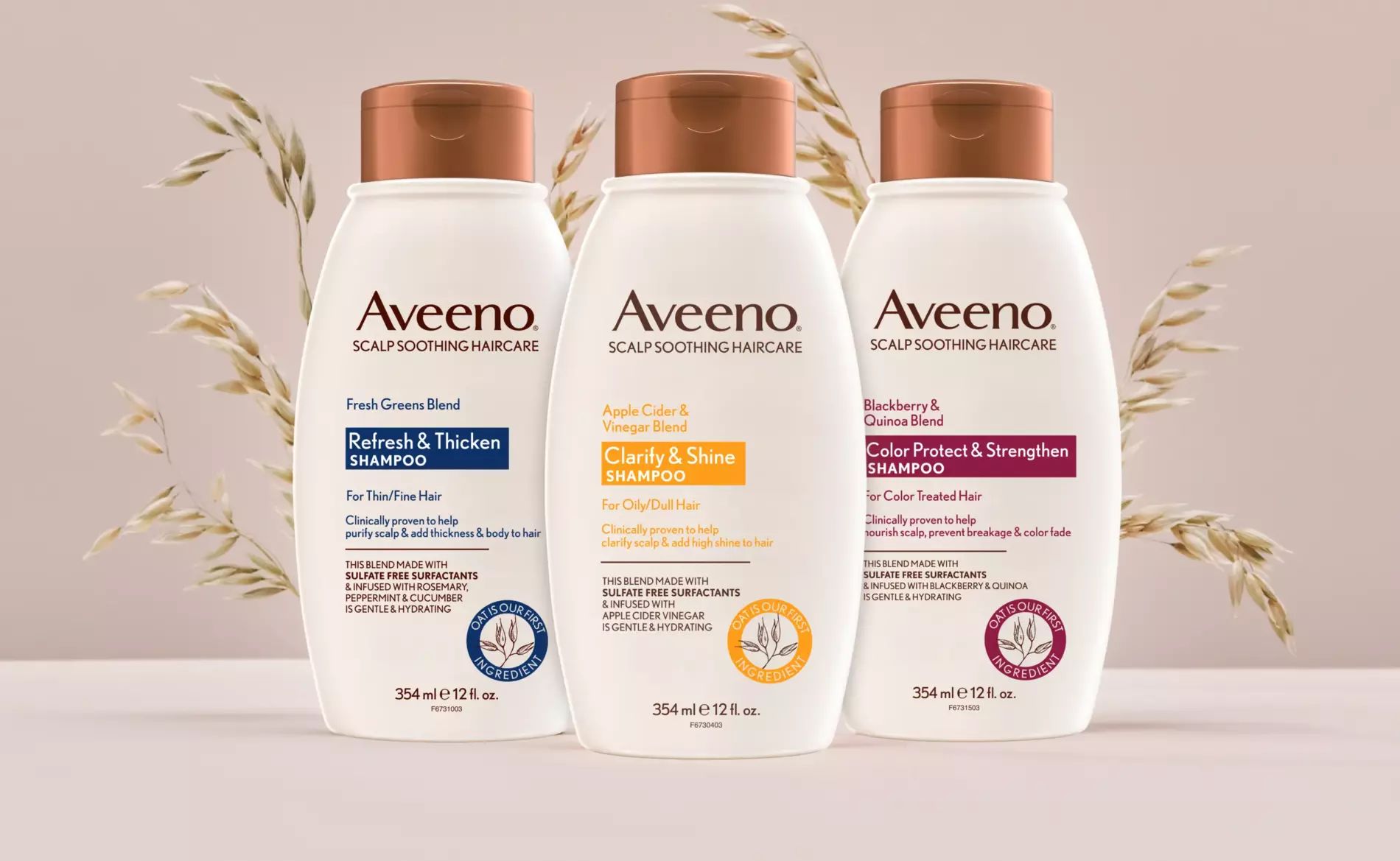 Three bottles of Aveeno® Scalp Soothing Haircare are displayed in front of a bunch of oats plants